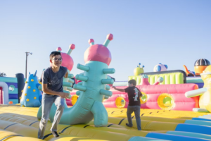 Two boys run on inflatable assault course