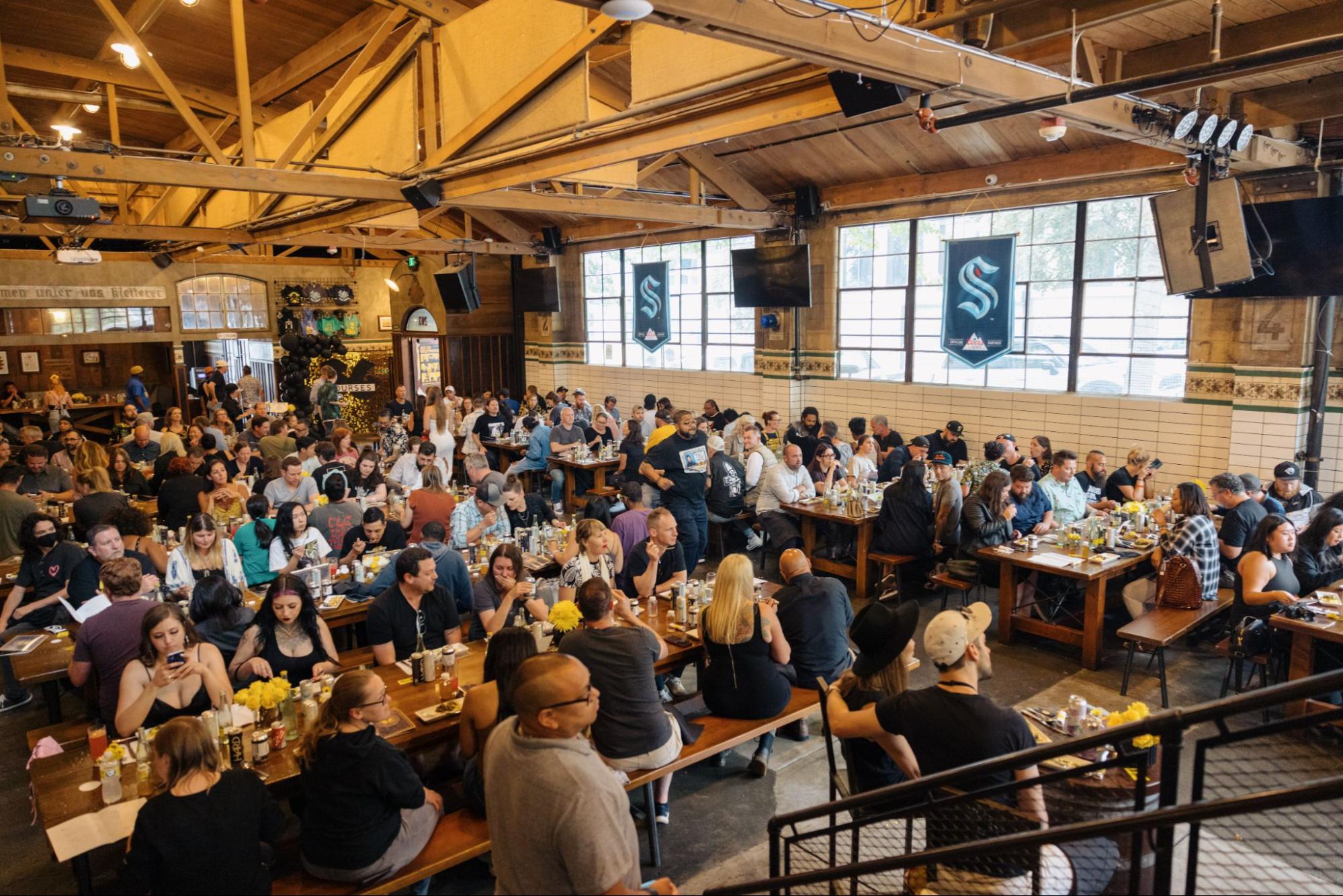 Guests sitting and eating at tables at All In Together Now Event