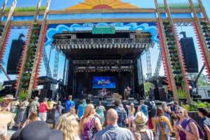 Image of a crowd in front of a stage at an outdoor music festival