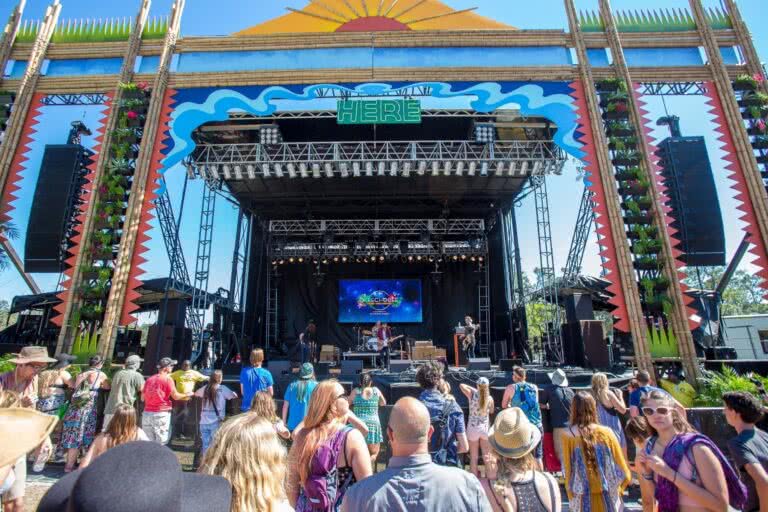 Image of a crowd in front of a stage at an outdoor music festival