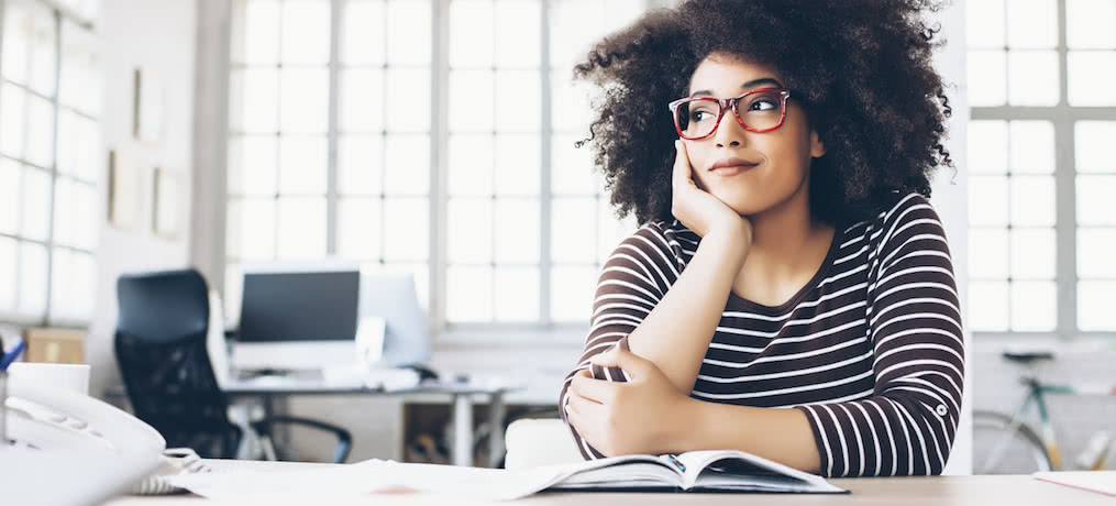 Woman sitting at her desk thinking.