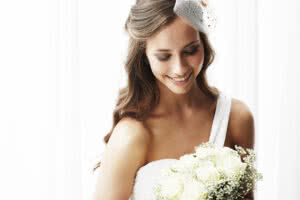 Picture of a wedding bride holding white flowers and smiling