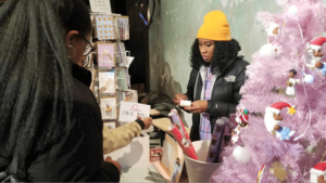 Christmas stall vendor chats with customers