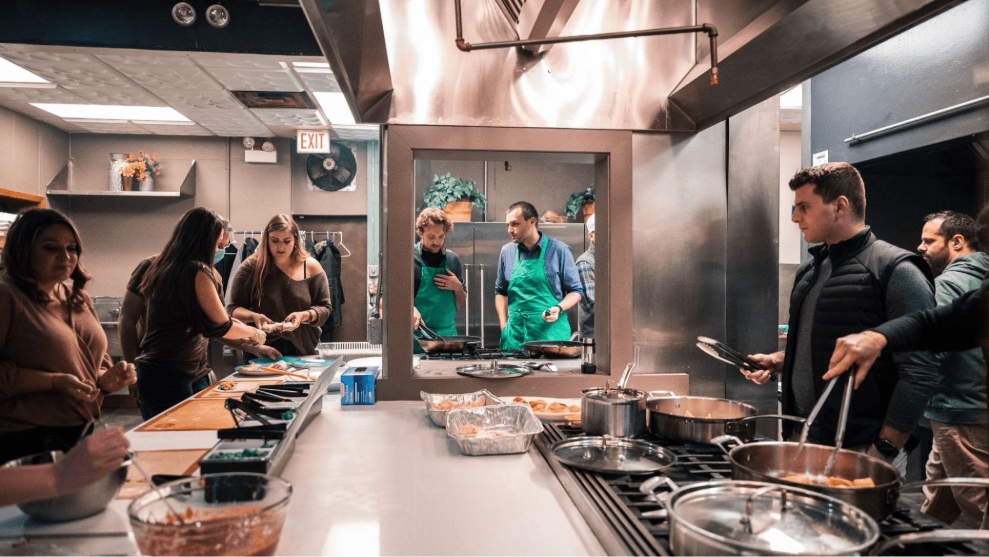 Event staff prepare food in an industrial kitchen space