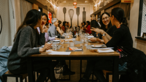 Crowd of diners sit at table chatting