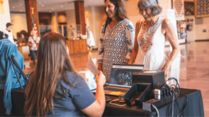 Female clients speaking to a desk worker.